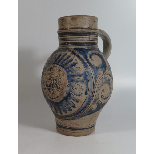 423 - A Westerwald Pottery Jug with incised decoration and initials GR, 23cm