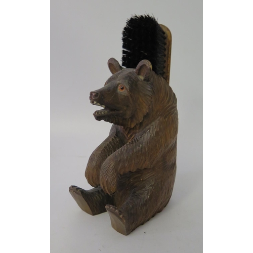 428 - A Carved Black Forest Bear modelled sitting with clothes brush to back, 21cm to top of brush