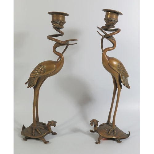 463 - A Pair of Nineteenth Century Chinese Bronze Candlesticks in the form of storks standing on the backs... 