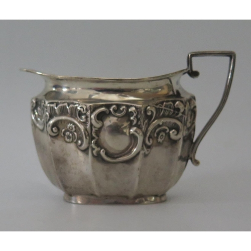 85 - An Edward VII Silver Milk Jug of decagonal form with embossed foliate scroll decoration, Birmingham ... 