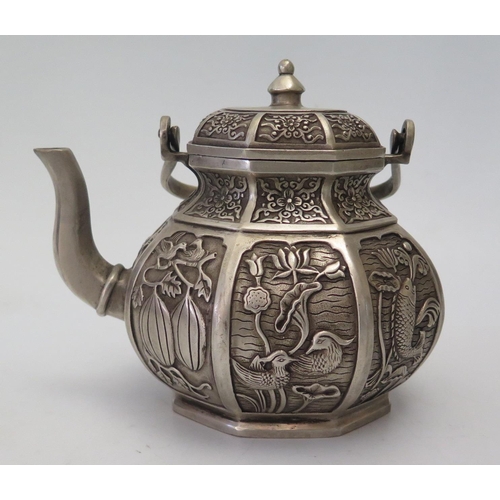 65a - A Chinese Hexagonal White Metal Teapot decorated with various reserves of animals and plants, four c... 