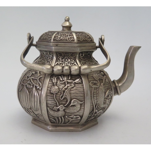 65a - A Chinese Hexagonal White Metal Teapot decorated with various reserves of animals and plants, four c... 