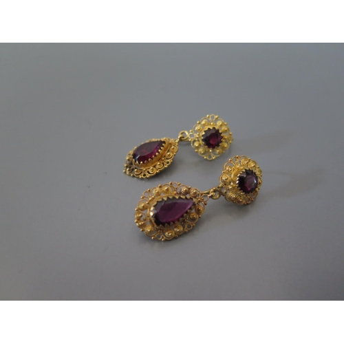 195 - A Pair of Garnet Pendant Earrings in a precious yellow metal filigree mount, 8.1g