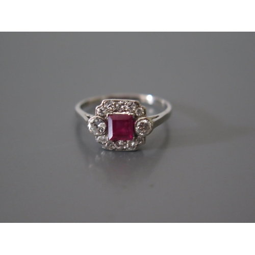 200d - A Ruby and Diamond ring in a precoius white metal setting (ruby c. .83ct)