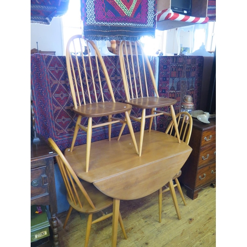 579 - An Ercol Light Elm Drop Leaf Circular Table and Four Chairs