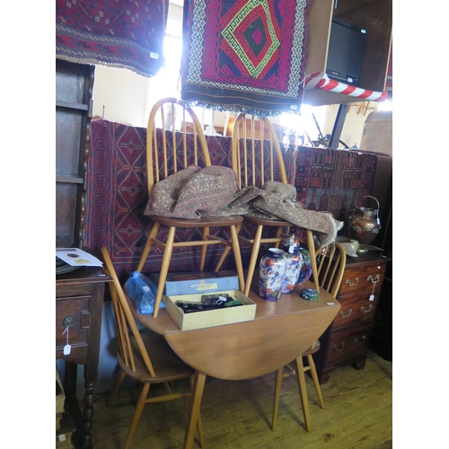 579 - An Ercol Light Elm Drop Leaf Circular Table and Four Chairs