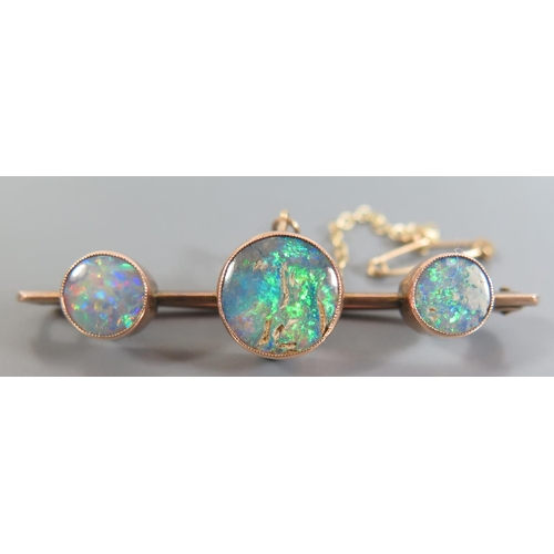 171 - An Black Opal Three Stone Brooch in precious yellow metal setting, c. 53mm, 4.7g