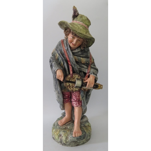 388 - A Continental Glazed Figure of a Boy playing a hurdy gurdy, 60cm