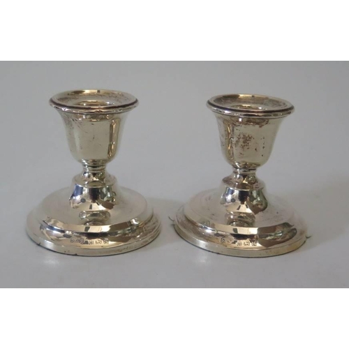 16 - A pair of modern loaded silver candlesticks