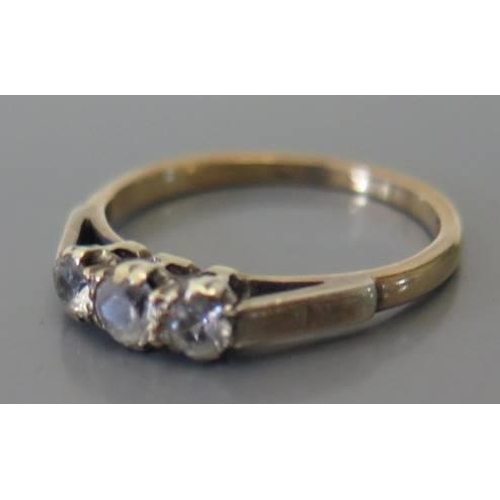 87 - A three stone ring in precious yellow metal setting