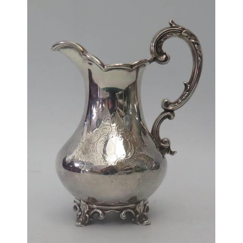 4 - A Victorian Silver Jug with chased foliate decoration and leaf embossed s-scroll handle, London 1846... 