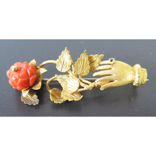 664 - A 19th Century High Carat Gold and Coral Mounted Brooch in the form of a gloved and ringed hand bear... 