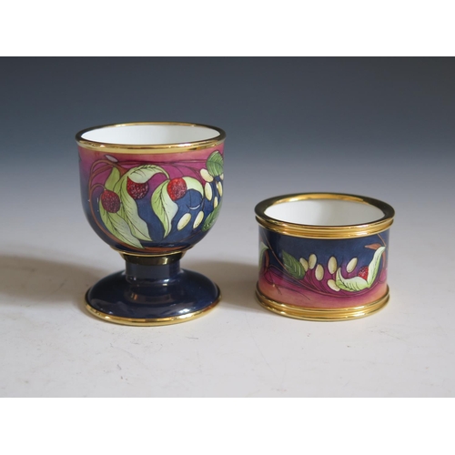 108 - A Modern Moorcroft Enamel Egg Cup and Napkin Ring Boxed Set decorated with berries, dated 03