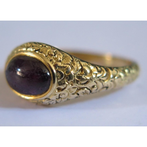 598 - A Georgian Foil Back Cabochon Purple Garnet Ring in a high carat unmarked gold setting with chased f... 