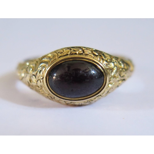 598 - A Georgian Foil Back Cabochon Purple Garnet Ring in a high carat unmarked gold setting with chased f... 