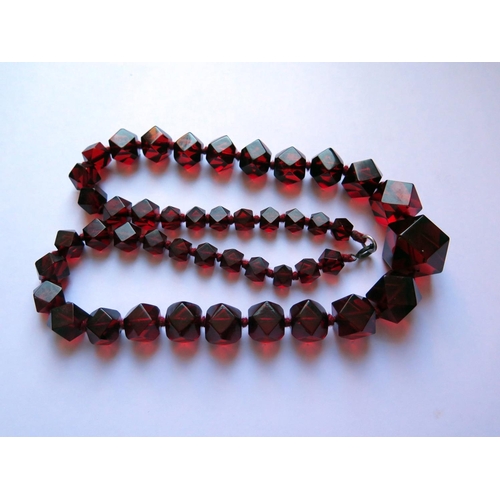 618 - A Graduated Faceted Faux Cherry Amber Bead Necklace, 61cm, 70.6g