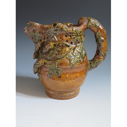 62 - A Mid 19th Century Sussex Rye Pottery Puzzle Jug with treacle glaze and green glazed applied hop and... 