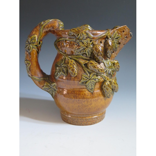 62 - A Mid 19th Century Sussex Rye Pottery Puzzle Jug with treacle glaze and green glazed applied hop and... 