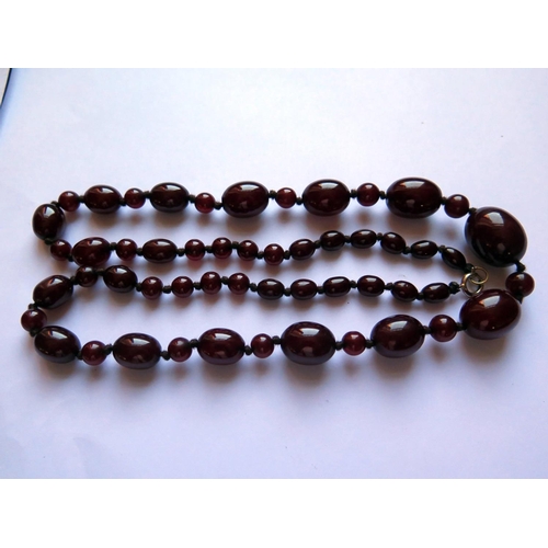 628 - A Graduated Faux Opaque Cherry Amber Bead Necklace, 70cm, 42.8g, largest bead 23x18mm