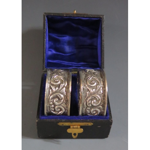 354 - A Cased Pair of Victorian Napkin Rings with embossed foliate scroll decoration, Birmingham 1899, Wil... 