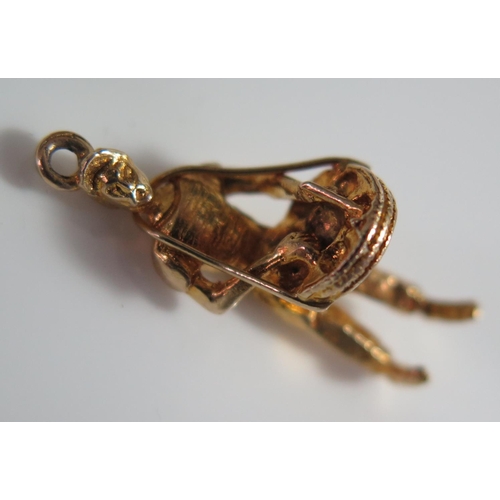 446 - A 9ct Gold Charm in the form of a man selling wares, 2g, 22mm high