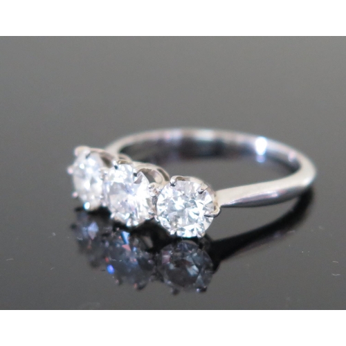 505a - A Three Stone Diamond Ring in an unmarked precious white metal setting (probably platinum), size N, ... 