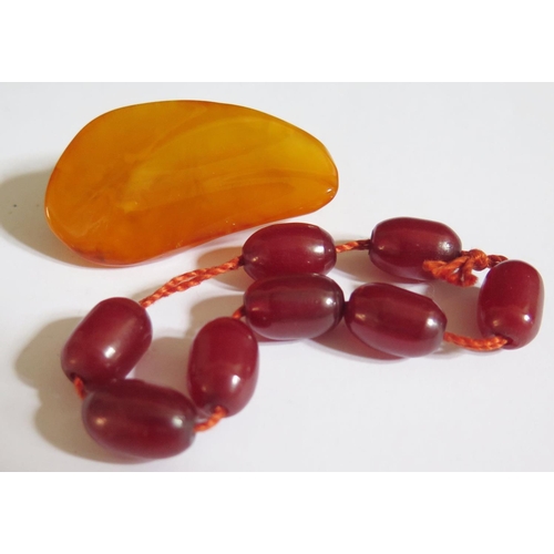 513 - A Baltic Amber Brooch 48x27mm 10.4g and faux cherry amber beads 8.6g