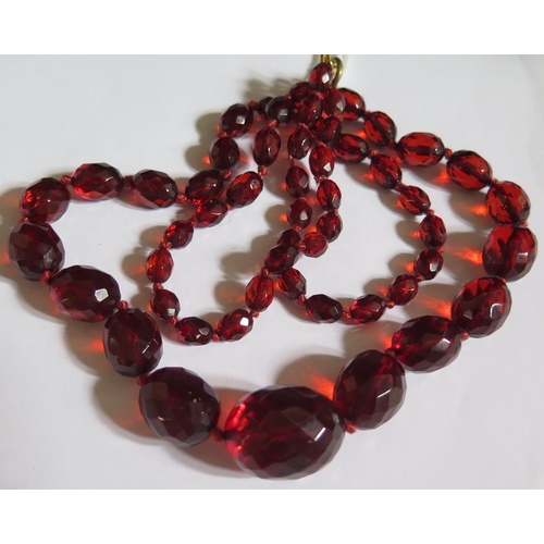 518 - A Graduated Faceted Faux Cherry Amber Bead Necklace, 67cm, 32.1g