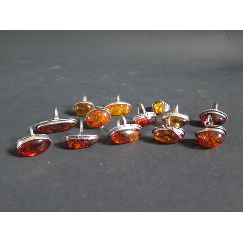 154g - A Collection of Silver Mounted and White Metal Amber Rings