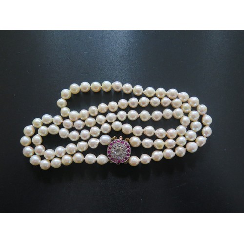 892 - A Twin Strand Pearl Choker with a rose cut diamond and ruby clasp, the central stone with a maximum ... 