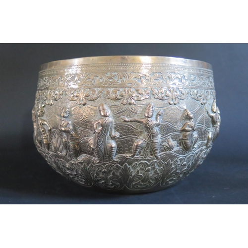 982 - A Large Burmese Silver Thabeik Bowl decorated figures in various poses with foliate scroll borders a... 