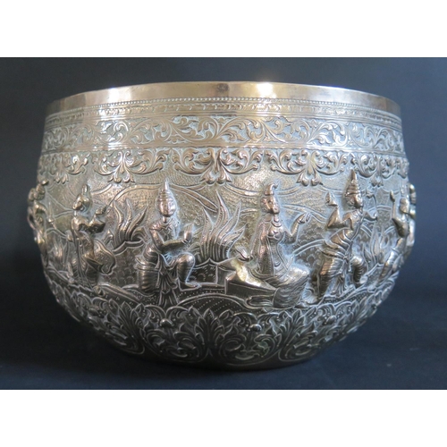 982 - A Large Burmese Silver Thabeik Bowl decorated figures in various poses with foliate scroll borders a... 