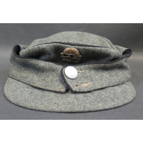 497 - A German WWII Army Field Cap with SS Totenkopf Skull badge and eagle cloth badge to side, inside wit... 