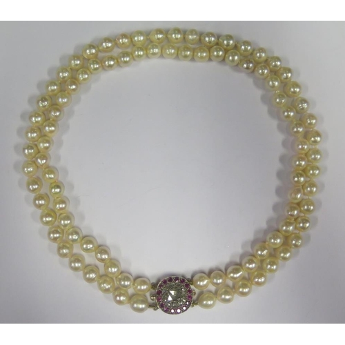 892 - A Twin Strand Pearl Choker with a rose cut diamond and ruby clasp, the central stone with a maximum ... 