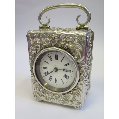 1050c - A Small Victorian Silver Carriage Clock decorated with scrolling foliate work, French movement with ... 