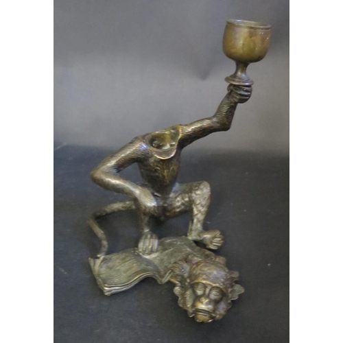 1193 - A Cast Bronze Monkey with detachable head, book at feet and holding a stemmed cup aloft, possibly a ... 