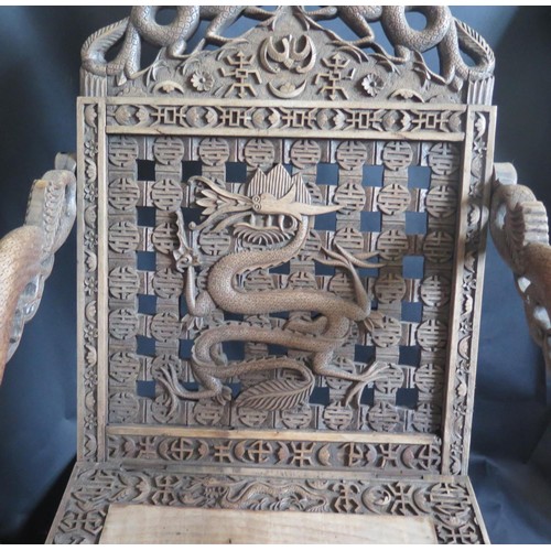 1053A - An Early 20th Century Chinese Carved Folding Throne Chair decorated with dragons and bat, 98cm high