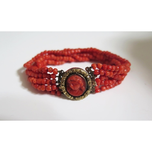 270 - A Georgian Coral Six Strand Bracelet with an unmarked gold clasp set with carved coral bust, 22.4g