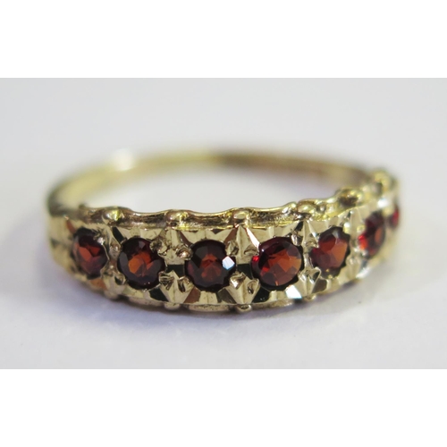 180 - A 9ct Yellow Gold and Garnet Seven Stone Ring, size Q, 2.2g