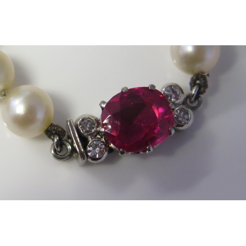 269 - A Single Strand Graduated Pearl Necklace with a ruby and diamond set precious white metal clasp, 55c... 