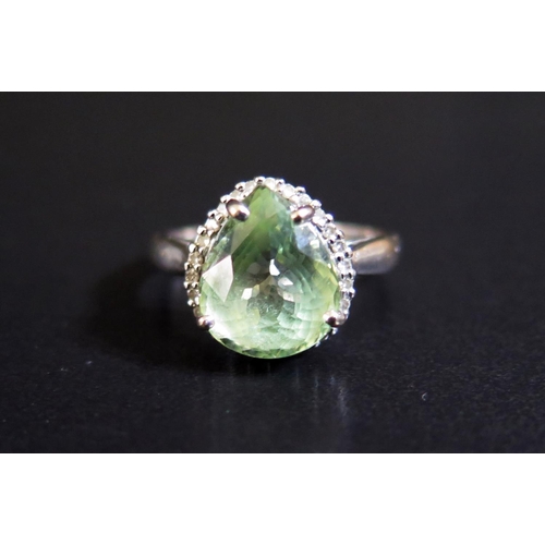 98 - An 18ct White Gold Ring set with Pale Green Pear Cut Stone and Diamond Surround, size N, 3.6g