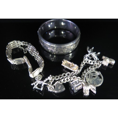 115A - A Silver Charm Bracelet including risque lady in bath, gate-link bracelet and hinged bangle, 38g