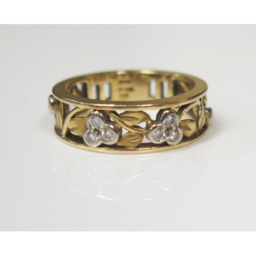 73 - An 18ct Yellow Gold and Diamond Ring in a floral openwork decorated 6.5mm wide shank, size M, 5.3g