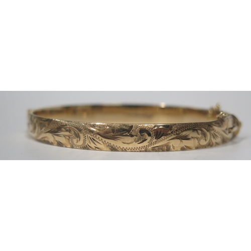 1676 - A Heavy 9ct Gold Hinged Bangle with chased foliate scroll decoration, Sheffield 1979, 22.8g