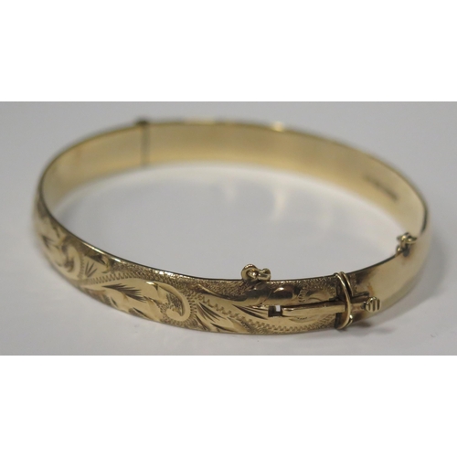 1676 - A Heavy 9ct Gold Hinged Bangle with chased foliate scroll decoration, Sheffield 1979, 22.8g