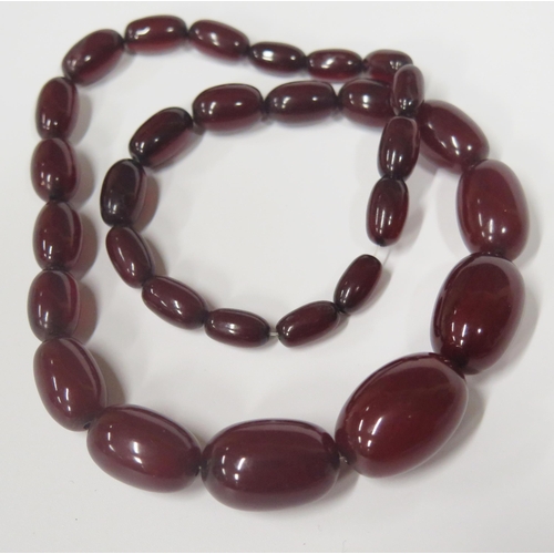 1721 - A Faux Cherry Amber Graduated Bead Necklace, largest bead 25x17mm, 36.7g