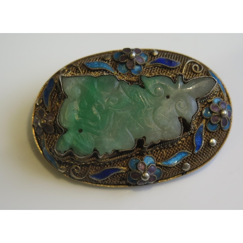 1898 - A Chinese Carved Jadeite Brooch in a silver gilt and enamel setting, 42x29mm