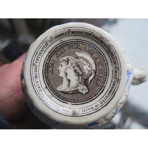 182 - A 19th Century Salt Glazed Mug decorated with a Bacchanalian scene in high relief, base marked 'THE ... 