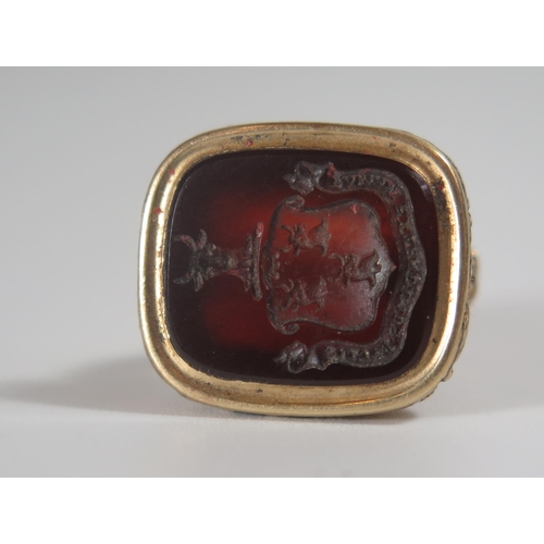 329 - An Early 19th Century Gold Seal with red stone matrix engraved with a motto and bulls heads, 25mm hi... 