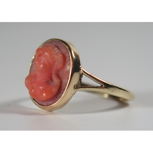 360 - An Antique Unmarked Gold and Coral Cameo Ring decorated with a female bust, size O.75, 4g